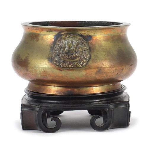522 - Large Chinese patinated bronze censer with animalia handles raised on a carved hardwood stand, six f... 