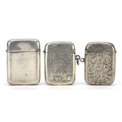 632 - Two Victorian and later silver vestas and a silver coloured metal example, each engraved with vines,... 