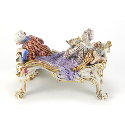 687 - Meissen, 19th century German porcelain figure group on a chaise longue, 20cm in length
