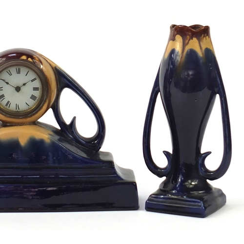 1395 - Art Noveau design three piece pottery clock garniture with treacle glaze, the largest 40cm wide
