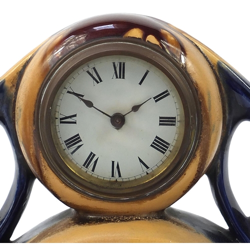 1395 - Art Noveau design three piece pottery clock garniture with treacle glaze, the largest 40cm wide
