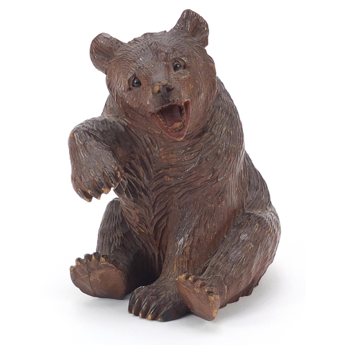 307 - Carved Black Forest seated bear with raised paw and open mouth, 14cm high