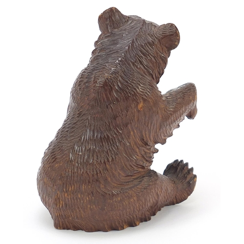 307 - Carved Black Forest seated bear with raised paw and open mouth, 14cm high