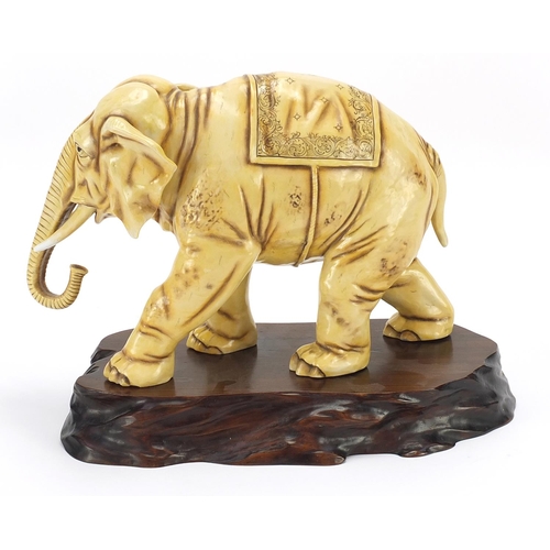 362 - Ivory coloured porcelain model of an elephant on wooden stand, blue anchor mark under one foot, lett... 