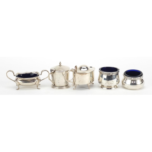 2420 - Five Edwardian and later silver cruets with blue glass liners including mustards with hinged lids, v... 