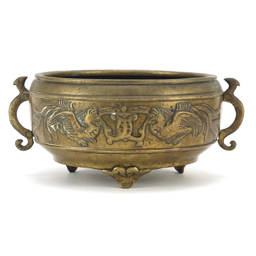 123 - Chinese patinated bronze tripod incense burner with twin handles decorated in relief with phoenixes,... 