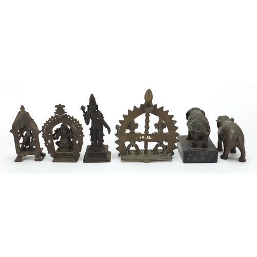 215 - Indian bronzes including votive figures and two elephants, one raised on a rectangular black slate b... 