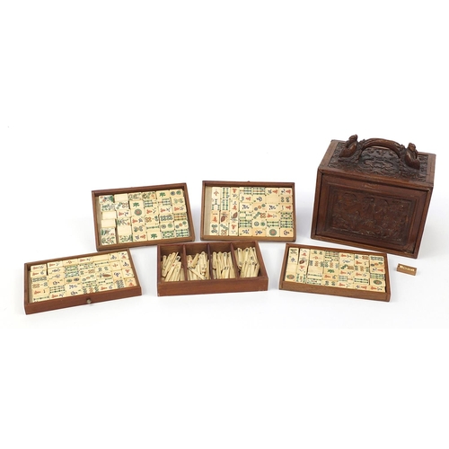 335 - Bone and bamboo Mah-jong set housed in a carved wooden box with figures and dragons