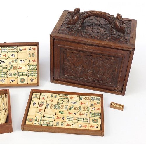 335 - Bone and bamboo Mah-jong set housed in a carved wooden box with figures and dragons