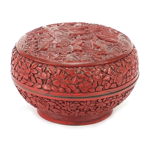 75 - Chinese cinnabar lacquer bun box and cover carved with figures amongst pagodas, 10cm high x 15cm in ... 