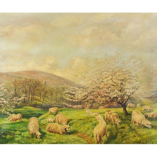 497 - Sheep grazing before blossom trees and mountains, oil on canvas, signed E J Dean, mounted and framed... 