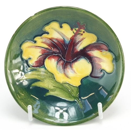 399 - Moorcroft footed dish hand painted with a flower head, paper label to the base, 9cm in diameter