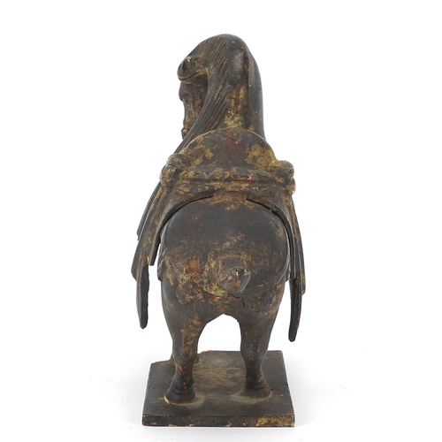 1092 - Chinese cast iron horse with one raised foreleg, standing on a metal plinth, 23cm in length