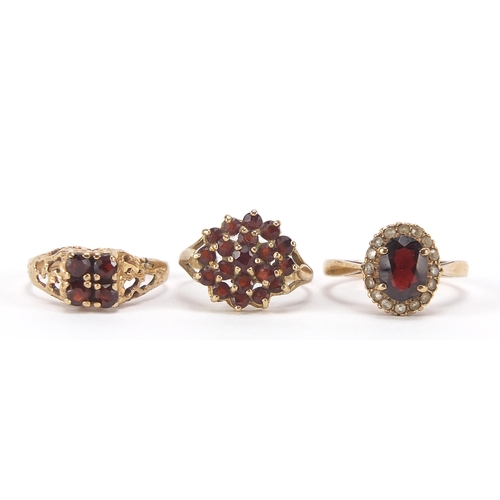 1763 - Three 9ct gold garnet rings including one set with clear stones, sizes K, L and M, 6.0g