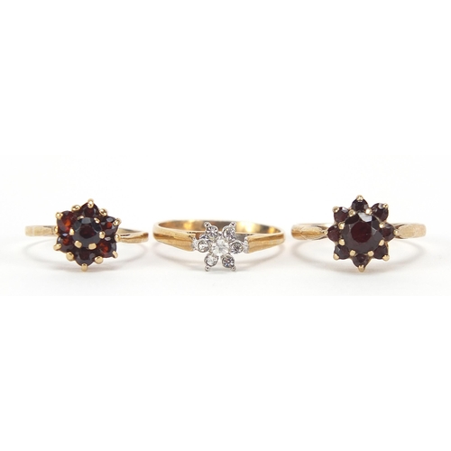 1715 - Two 9ct gold garnet cluster rings and a gold coloured metal clear stone ring, sizes K, L and M, 5.6g