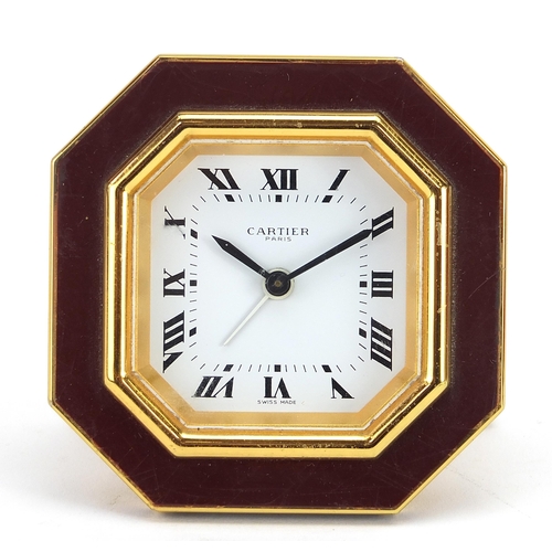 268 - Cartier red and gold coloured desk strut clock, the dial having Roman numerals, housed in a red pres... 