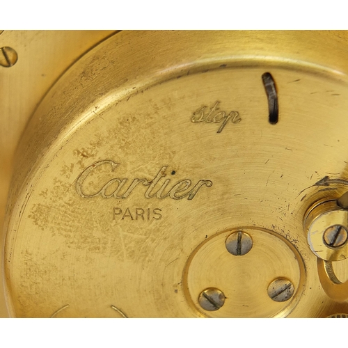 268 - Cartier red and gold coloured desk strut clock, the dial having Roman numerals, housed in a red pres... 