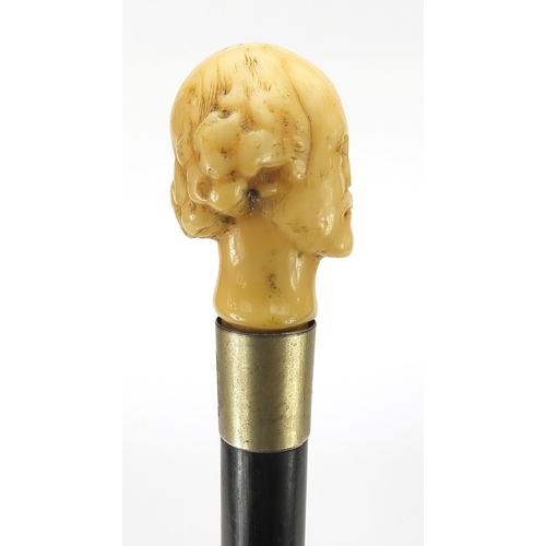 324 - Ebony walking stick with carved ivory pommel in the form of William Shakespeare, 82cm in length