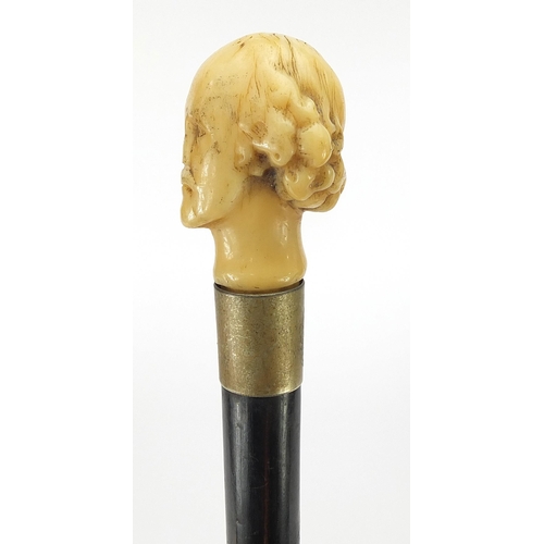 324 - Ebony walking stick with carved ivory pommel in the form of William Shakespeare, 82cm in length