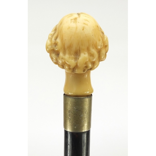 324 - Ebony walking stick with carved ivory pommel in the form of William Shakespeare, 82cm in length