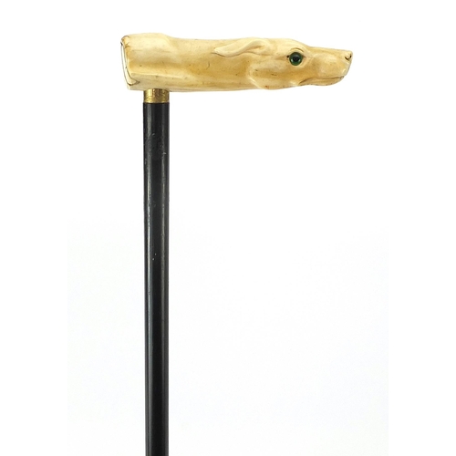 321 - Ebony walking stick with carved ivory pommel in the form of a dog's head with green glass eyes, 90cm... 