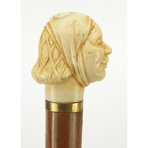 323 - Hardwood and ebony walking stick with carved ivory pommel in the form of a lady's head, 90cm in leng... 