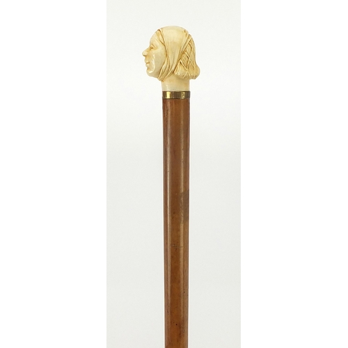 323 - Hardwood and ebony walking stick with carved ivory pommel in the form of a lady's head, 90cm in leng... 