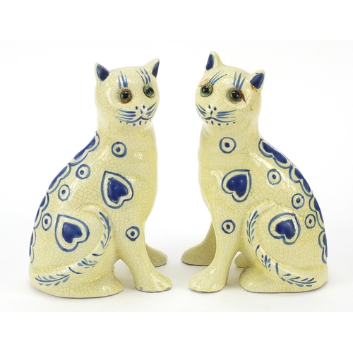 383 - Two Galle style pottery cats with glass eyes, 14cm high