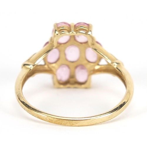 1694 - 9ct gold pink stone cluster ring with pierced shoulders, size N, 2.1g