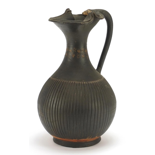147 - South Italian pottery single handled vessel hand painted with a vine around the neck, 26cm high