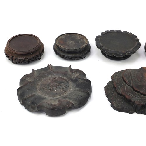 62 - Thirteen Chinese carved hardwood stands to including a plate stand, the largest 30cm high