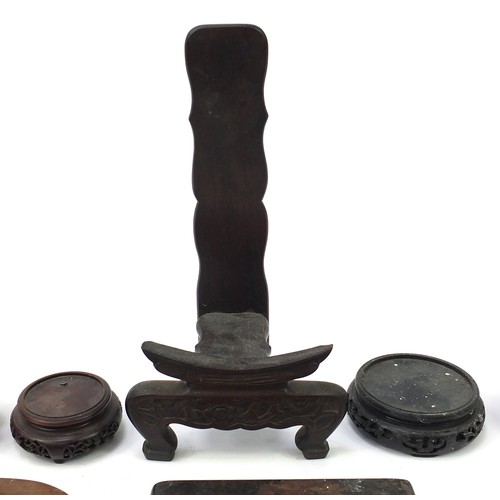 62 - Thirteen Chinese carved hardwood stands to including a plate stand, the largest 30cm high