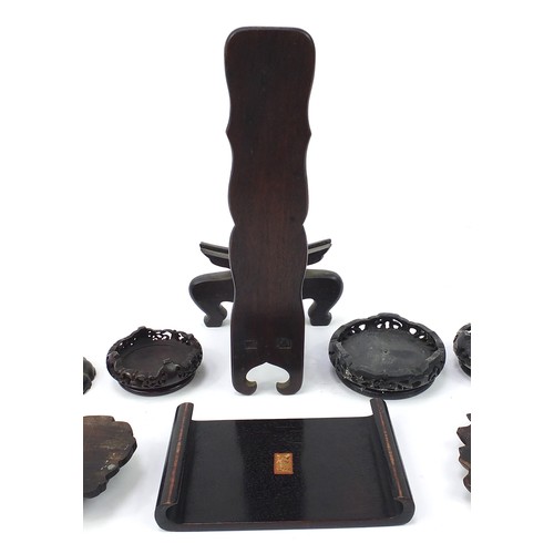 62 - Thirteen Chinese carved hardwood stands to including a plate stand, the largest 30cm high