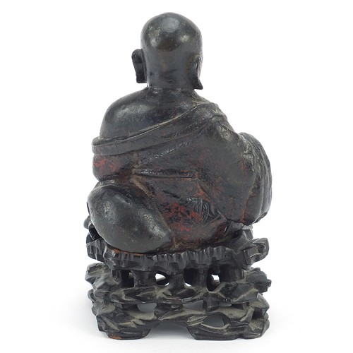 112 - Chino Tibetan patinated bronze figure of Buddha sitting on a carved hardwood base, 18cm high