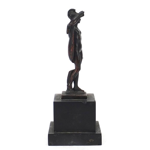 219 - Antique patinated bronze figure of a nude figure with robe, raised on a square black slate base, pos... 