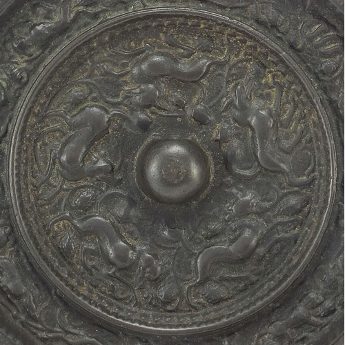 119 - Chinese patinated bronze hand mirror cast with mythical animals and flowers, 14.5cm in diameter