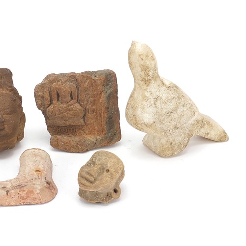 166 - Stone antiquities including a marble carving of a bird and stone fragments, the largest 13cm high