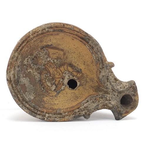 172 - Roman terracotta oil lamp decorated in relief with a figure, 9cm in length