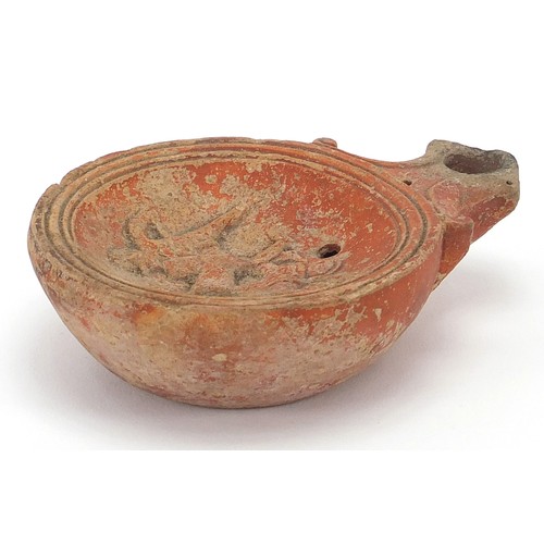 173 - Roman terracotta oil lamp decorated in relief with two figures, 11cm in length