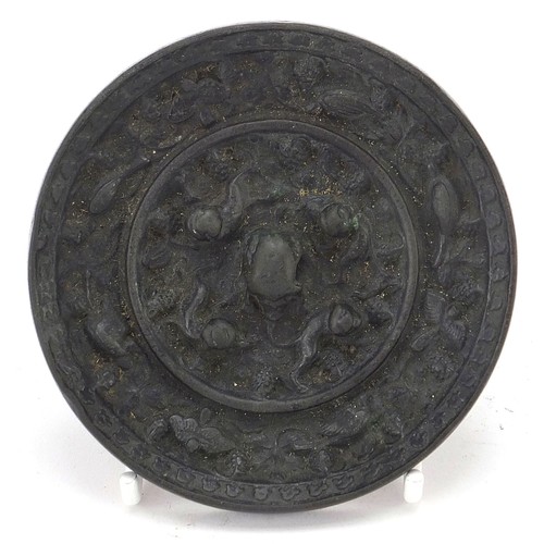 120 - Chinese patinated bronze hand mirror cast with birds of paradise and flowers, 9.5cm in diameter