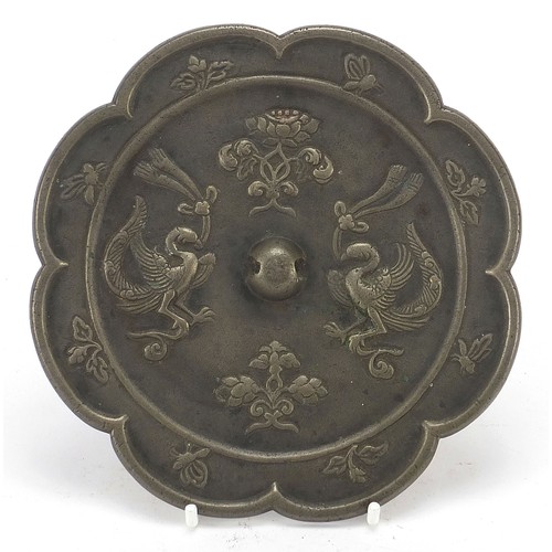 121 - Chinese patinated bronze hand mirror cast with phoenixes and flowers, 15.5cm in diameter