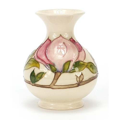 136 - Moorcroft pottery vase decorated with flowers in the Magnolia pattern, 13cm high