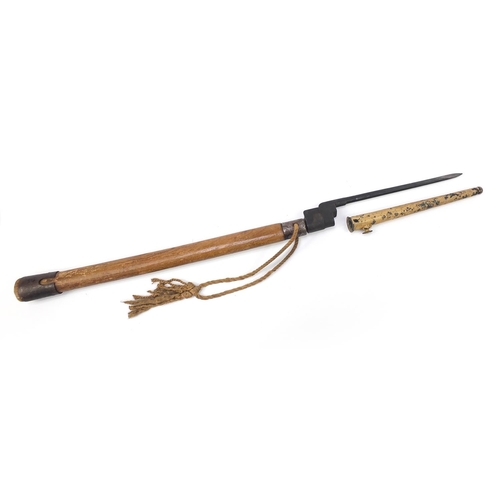1445 - Military interest short bayonet with sheath fitted to a wooden handle, 69cm in length