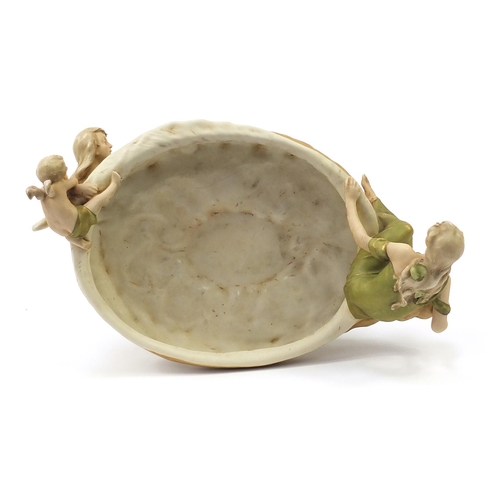 216 - Large Royal Dux porcelain centrepiece with children climbing a lily pad, 43.5cm high