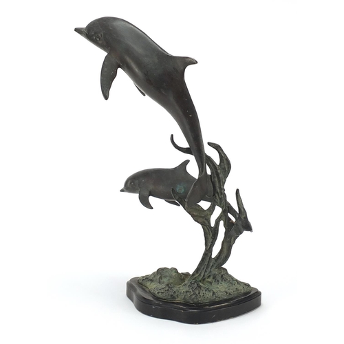 427 - Bronze dolphin group raised on a shaped black slate base, 36cm high