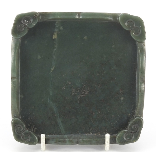 301 - Chinese carved green jade stand with scrolled feet, 11cm x 11cm