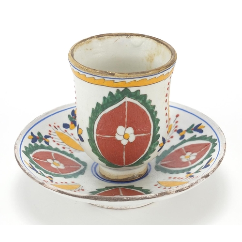 68 - Turkish Kutahya pottery cup and saucer hand painted with flowers, the largest 13.5cm in diameter