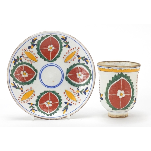 68 - Turkish Kutahya pottery cup and saucer hand painted with flowers, the largest 13.5cm in diameter