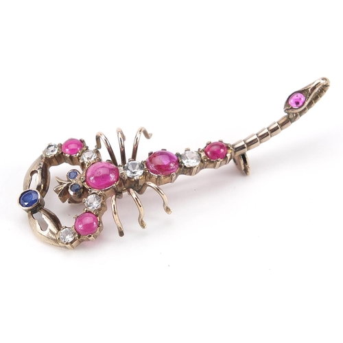 1591 - Unmarked gold scorpion bar brooch set with diamonds, cabochon rubies and blue sapphires, the largest... 