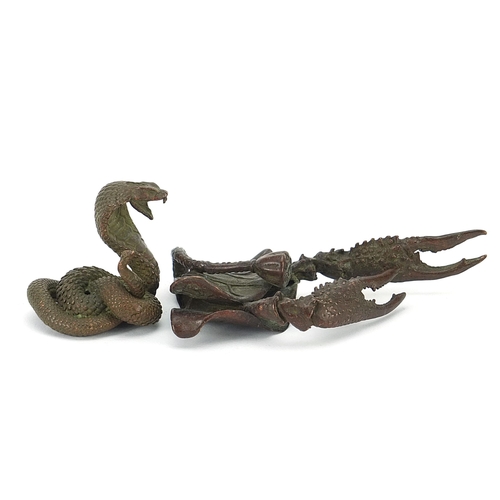 308 - Two Japanese patinated bronze animals comprising cobra and crab, the largest 10.5cm in length